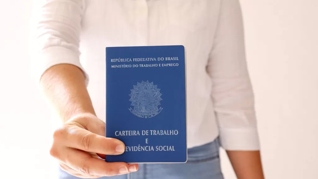 Mulher segurando sua carteira de trabalho CTPS