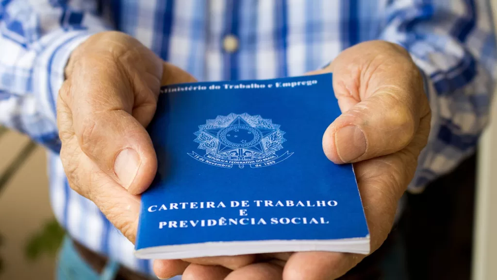 Homem segurando a sua carteira de trabalho com as duas mãos